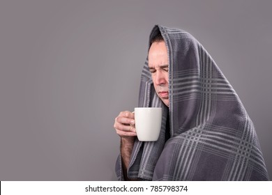 Sick Man Holding A Hot Drink And Trying To Stay Warm.