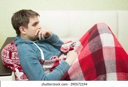 Sick Man Lying On Sofa  At Home In Living Room