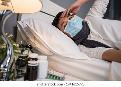 sick man in medical mask is headache and suffering from virus disease and fever in a bed, coronavirus (covid-19) pandemic concept. - Shutterstock ID 1741615775