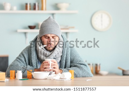 Sick man sitting at kitchen table