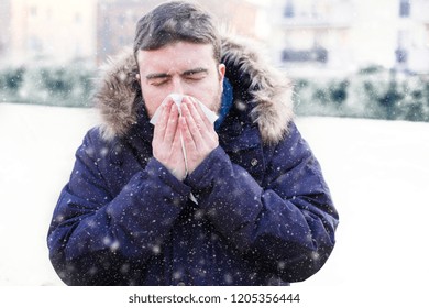 Sick Man Sneezing In The Kleenex In Winter