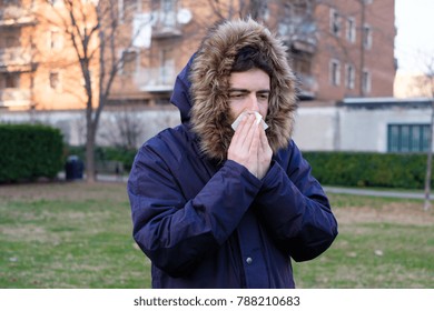 Sick Man Sneezing In The Kleenex In Winter