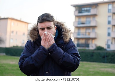 Sick Man Sneezing In The Kleenex In Winter