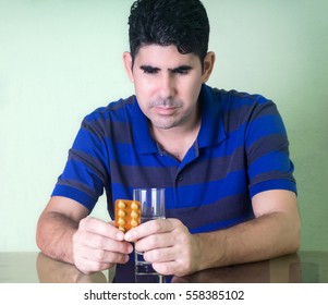 Sick man with a tablets strip and a glass of water