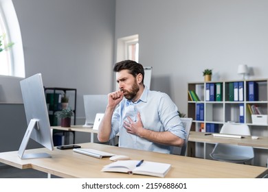 Sick man working in the office, has a bad cough, coughing businessman at the computer - Shutterstock ID 2159688601