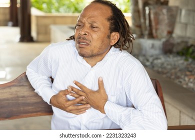 Sick middle age African black man with heart attack or chest pain - Powered by Shutterstock