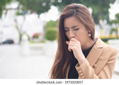 Sick, Not Vaccinated Asian Woman Suffering From Coughing, Sore Throat, Cold, Flu Or COVID-19 Coronavirus, Long COVID Syndrome