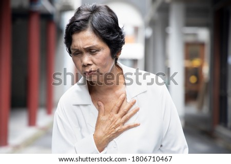 sick old senior woman suffering from GERD or acid reflux