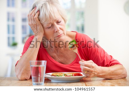 Sick older woman trying to eat
