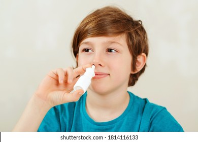 Sick School Boy With Runny Nose Using Nasal Medicine Spray. Nasal Allergy. Kid With Ill Disease Treatment Season. Allergic Kid, Flu Season. Boy Has A Virus, Runny Nose And Headache.