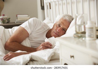 Sick Senior Man In Bed At Home