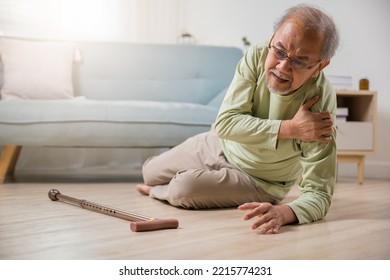 Sick senior old man falling down lying on the ground because stumbled at home alone with wooden walking stick in living room, elderly man grandfather having accident while walk with cane walker - Shutterstock ID 2215774231