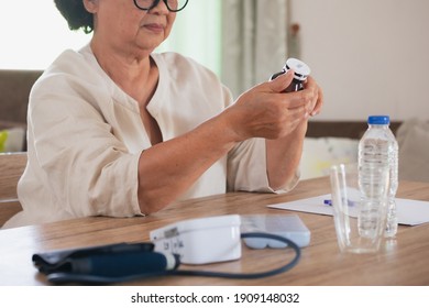 Sick Senior Woman Hold Pills Bottle And Read Medicine Prescription Label And Looking At Medicine Instructions Side Effects At Home. Health And Medical Concept.