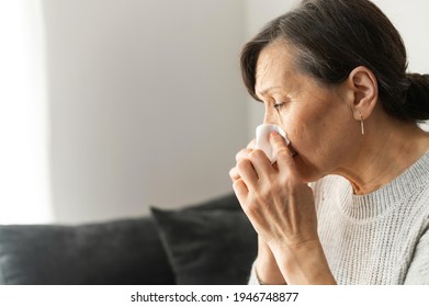 Sick Senior Woman Sneezing, Using A Paper Napkin For Cleaning Nose, Has Runny Nose And Cough, An Older Female Got A Viral Infection, Side View