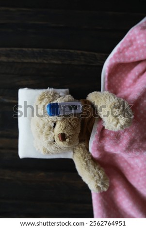 Sick Teddy Bear in Bed with Thermometer and Pink Blanket, Cute Plush Toy Health Concept