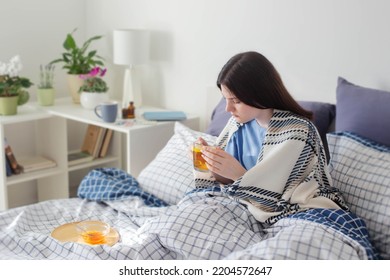 Sick Teen Girl With Tea On Bed In White Room