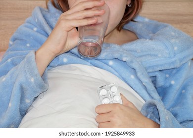 Sick Teenager Girl Taking Medication While Lying In Bed.