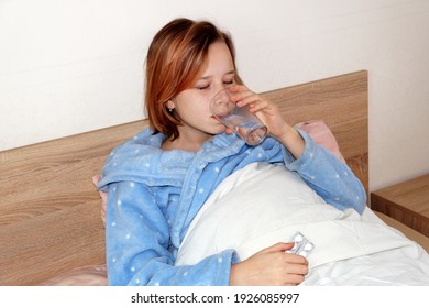 Sick Teenager Girl Taking Medication While Lying In Bed.