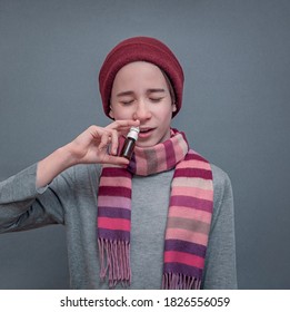 Sick Teenager With A Runny Nose, A Child Spraying Medicine Into The Nose, Using A Nasal Spray, Treating The Flu Or Allergic Rhinitis