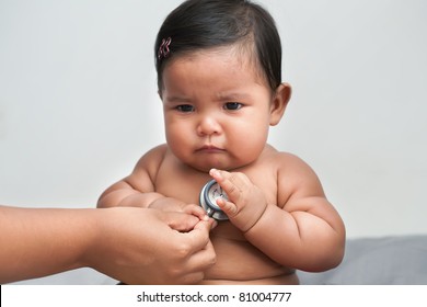 Sick And Upset Baby Girl Getting A Medical Check Up By Doctor