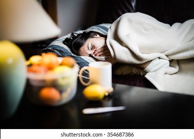 Sick Woman In Bed,calling In Sick,day Off From Work.Thermometer To Check Temperature For Fever.Vitamins And Hot Tea In Front.Flu.Woman Caught Cold.Virus.Sick Woman Laying In Bed Under Wool Blanket 