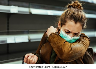 Sick woman buying in supermarket and coughing into elbow during COVID-19 pandemic.  - Powered by Shutterstock