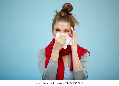 Sick Woman With Cold Caught Sneezing Into Tissue. Sick Woman With Headache Isolated Portrait With Red Scarf On Light Blue Back.