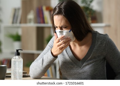 Sick Woman Coughing With Coronavirus Symptoms Wearing Mask Sitting On A Desk At Home In The Night