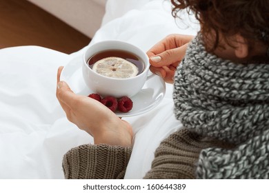 Sick Woman Drinking Hot Tea With Lemon And Raspberries