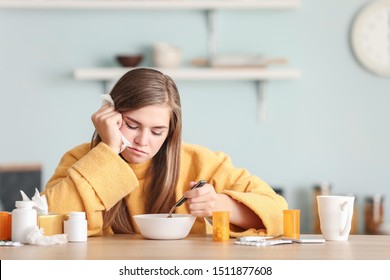 Sick Woman Eating Chicken Soup In Kitchen