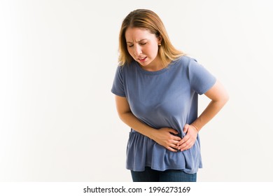 Sick woman having pain and suffering from gallstones. Caucasian woman with a gallbladder disease rubbing a side of her stomach - Shutterstock ID 1996273169