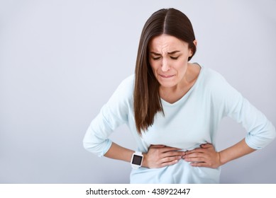 Sick woman having a stomach ache - Shutterstock ID 438922447