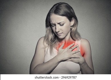 Sick Woman With Heart Attack, Pain, Health Problem Holding Touching Her Chest Colored In Red With Hands Isolated On Gray Wall Background. Human Face Expression 