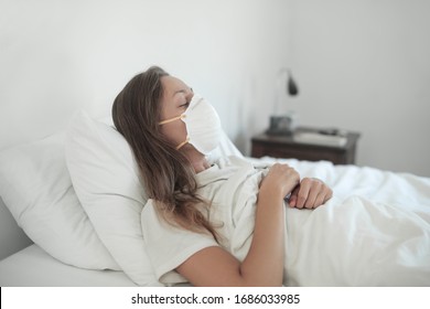 Sick woman lying in the bed wearing a face mask - Shutterstock ID 1686033985