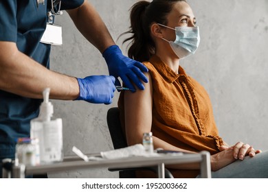 Sick Woman In Medical Mask Getting A Vaccine Shot Sitting In A Cabinet