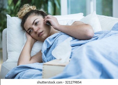 Sick Woman With Phone And Tissues In Bed