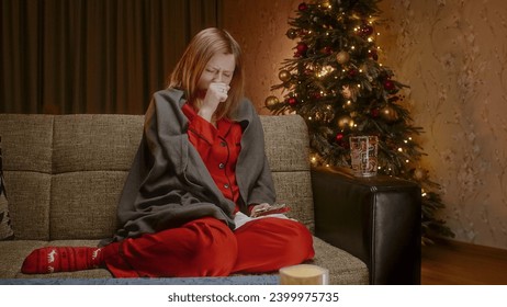 Sick woman sitting on a couch and sneezing, and a man gives her a pill and a glass of water, a decorated Christmas tree on the background - Powered by Shutterstock