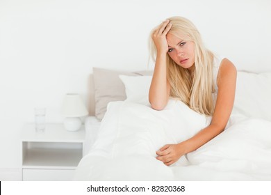 Sick Woman Sitting On Her Bed While Waking Up