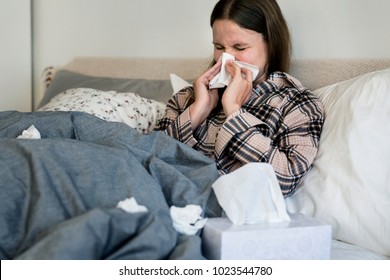 Sick Woman Sneezing In Bed