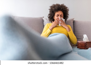 Sick woman sneezing and blowing nose. Photo of african american woman. Medical concept. African american woman feeling unwell and coughing as symptom for cold or bronchitis. Healthcare concept.  - Powered by Shutterstock