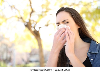 病人が公園で鼻を拭いてくしゃみをする