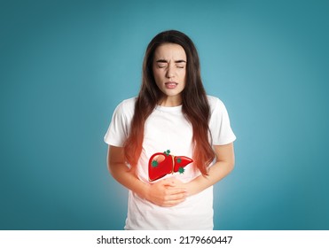 Sick woman suffering from pain and illustration of unhealthy liver on light blue background. Viral hepatitis - Shutterstock ID 2179660447
