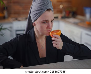 Sick Woman Trying To Sense Smell Of Fresh Orange, Symptoms Of Covid-19, Corona Virus Infection. Long-lasting Covid19 Symptom. Loss Of Taste Of Food. Loss Of Smell As One Of Long-term Sars-cov-2 Effect