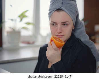 Sick Woman Trying To Sense Smell Of Fresh Orange, Has Symptoms Of Covid-19, Corona Virus Infection. Long-lasting Covid19 Symptom. Loss Of Taste Of Food As One Of Long-term Sars-cov-2 Effects.