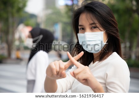 sick woman wearing mask, stopping virus outbreak; concept of biohazard, preventive health care, coronavirus outbreak control, social distancing, physical distancing, personal distancing in public