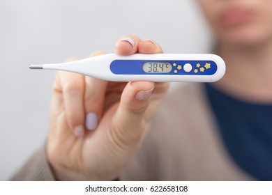 Sick women with a thermometer - Shutterstock ID 622658108