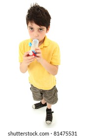 Sick Young Boy Child Using Asthma Inhaler With Spacer Chamber Over White.  Has Periorbital Hyperpigmentation.