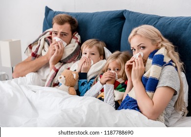 Sick Young Family Lying In Bed