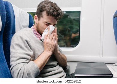 Sick Young Man Blowing His Nose Sitting In The Train