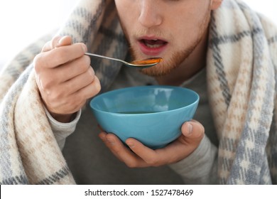 Sick Young Man Eating Soup To Cure Flu, Closeup